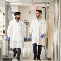 Two male Arvinas scientific staff walking through lab in conversation